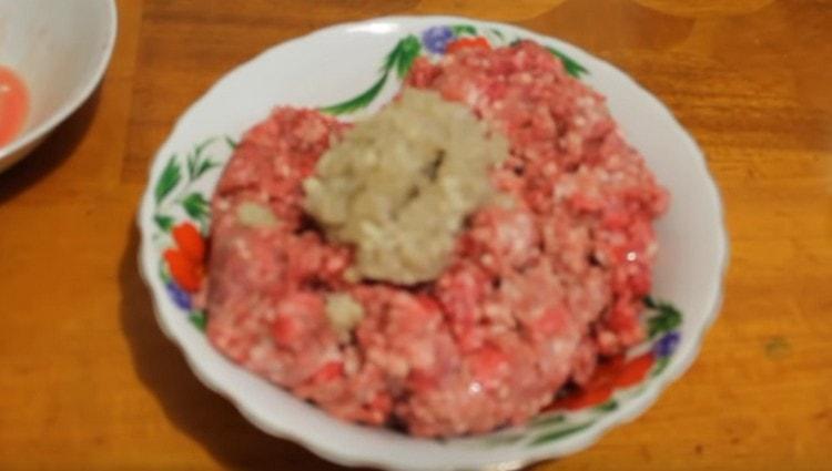 Add chopped onion and garlic to the minced meat.