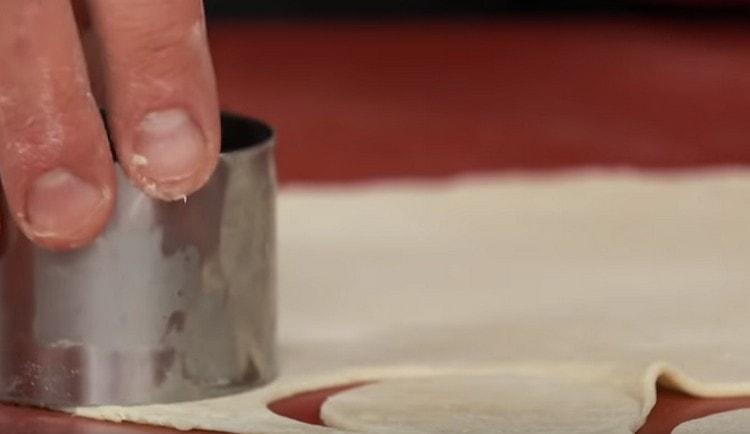 Using a mold, cut out round dough pieces from the dough.