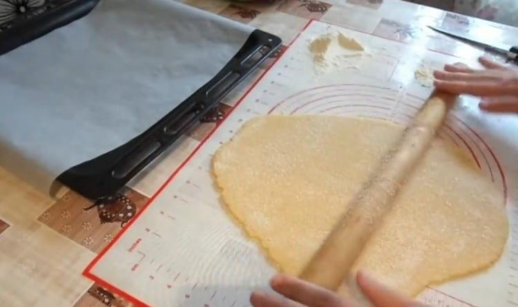 Saupoudrer la pâte de sucre et marcher légèrement avec un rouleau à pâtisserie.