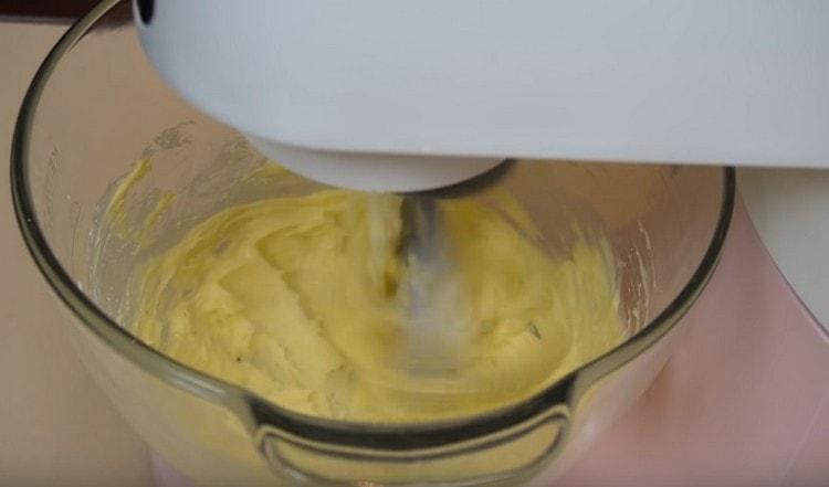 Battez le beurre avec la poudre avec un mélangeur jusqu'à splendide.