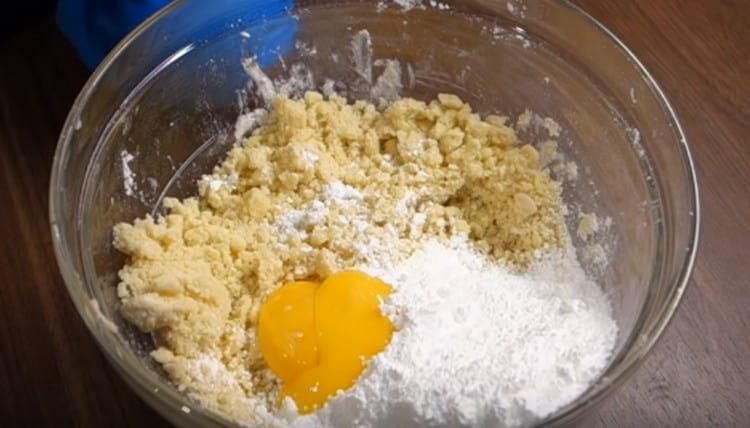 Rezultirajućim mrvicama dodajte žumanjke i šećer u prahu.