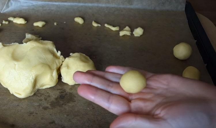 Nous roulons des petites boules de la pâte dans le réfrigérateur.