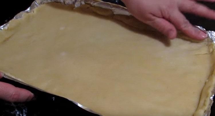 We lay the rolled dough on a baking sheet covered with foil or parchment.