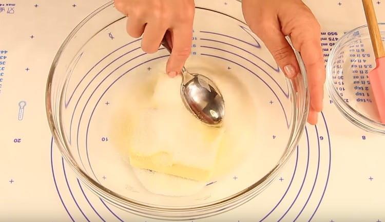 Agregue azúcar a la mantequilla y muela la masa con una cuchara.