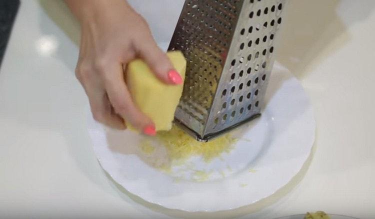 Sur une râpe fine, nous frottons du fromage à pâte dure.