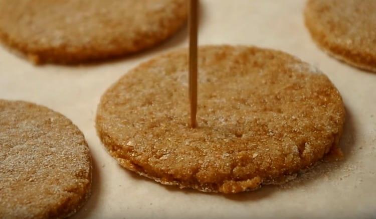 Having laid the cookies on a baking sheet, prick it with a fork or a toothpick.