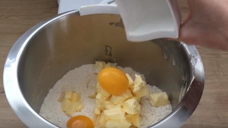 Étaler deux jaunes d'œufs pour la farine et le beurre.