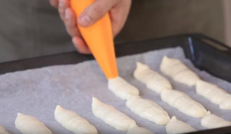 Nous déposons des biscuits sous forme de doigts (ou de bâtons) sur une plaque à pâtisserie recouverte de papier sulfurisé.