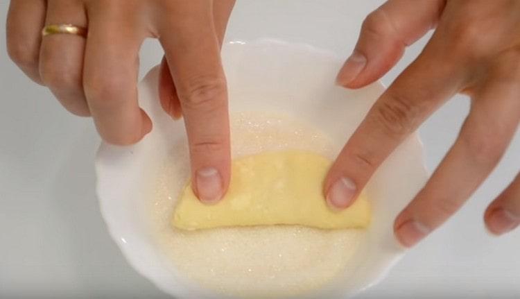 Fold the dough in half with sugar inside and again dip it with sugar on one side.