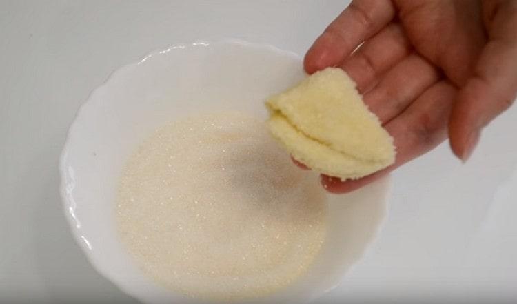 Trempez dans le sucre d'un côté des triangles de pâte et mettez l'autre sur une plaque à pâtisserie.