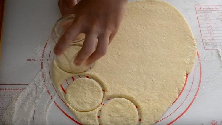 Exprimimos círculos de la masa con un vaso.