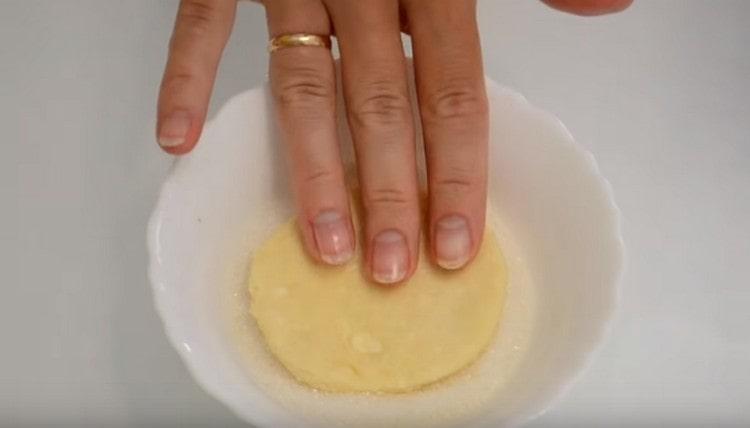 Dip a circle of dough into sugar on one side.