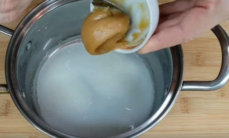 Versez de l'eau dans une casserole, ajoutez le sucre et le miel.