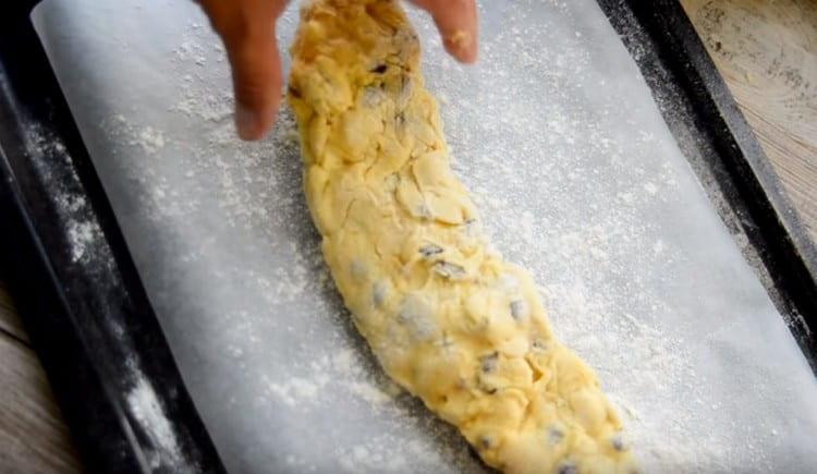 Transférer délicatement cette saucisse sur une plaque à pâtisserie recouverte de papier sulfurisé et saupoudrée de farine.