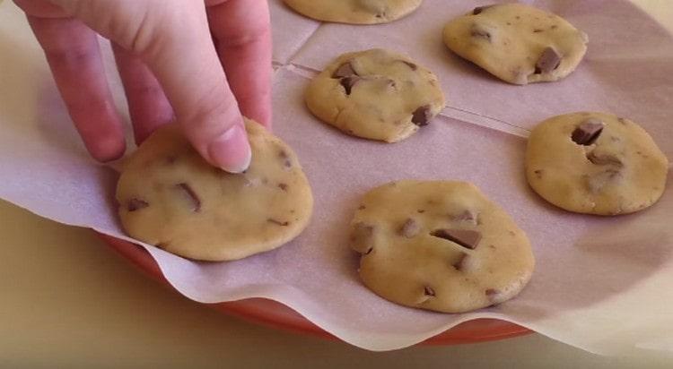 Avec nos mains, nous formons de petits gâteaux plats à partir de tesat et nous les plaçons sur du parchemin.