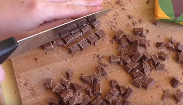 With a knife, we chop the chocolate into small pieces.