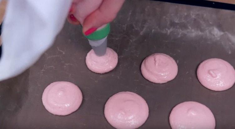 We cover the baking sheet with parchment and plant circles of dough on it.