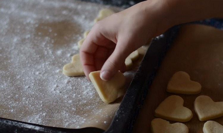 Nous plaçons les biscuits sur une plaque à pâtisserie, recouverte de papier sulfurisé et saupoudrée de farine, et envoyons au four.