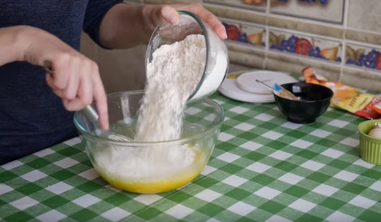 Gradually add flour to the liquid components and knead the dough.