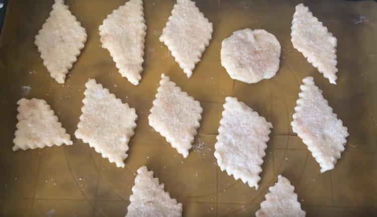 Kolačiće širimo na lim za pečenje obložen papirom za pečenje, nakon što svaki komad umočimo u mješavinu cimeta sa šećerom.