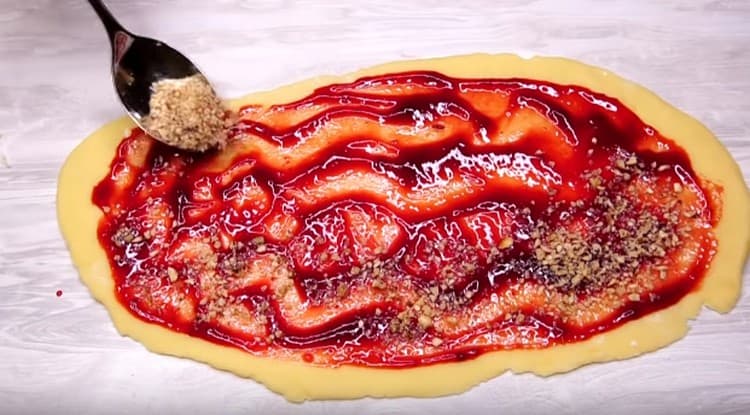 Saupoudrer une couche de confiture avec des noix hachées.