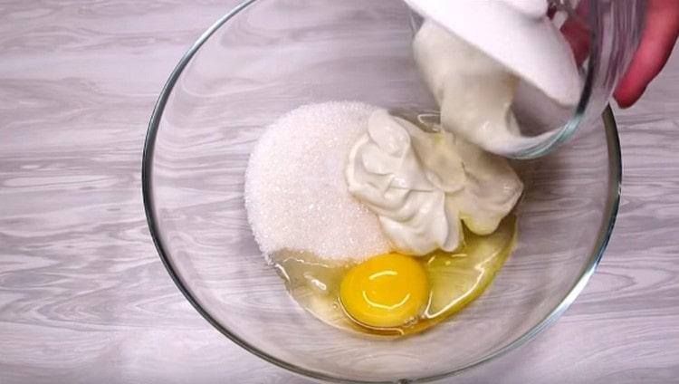 U drugoj posudi povežite jaje. kiselo vrhnje, šećer i sol.