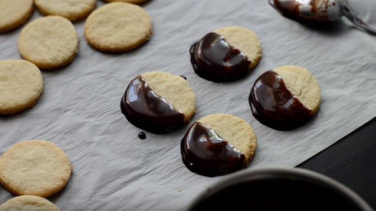 Each cookie is half dipped in icing and left to dry.