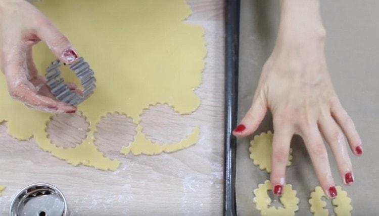 De la pâte, nous découpons les bases pour les biscuits et les plateaux avec des moules, dans lesquels il devrait y avoir des trous bouclés.