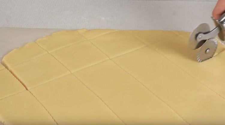 Couper la pâte déroulée avec un couteau à pizza en petits carrés.