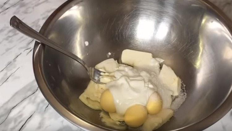 Combine boiled egg yolks, sugar, butter and sour cream in a bowl.