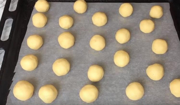 Put the balls of dough with nuts inside on a baking sheet and send to bake in the oven.