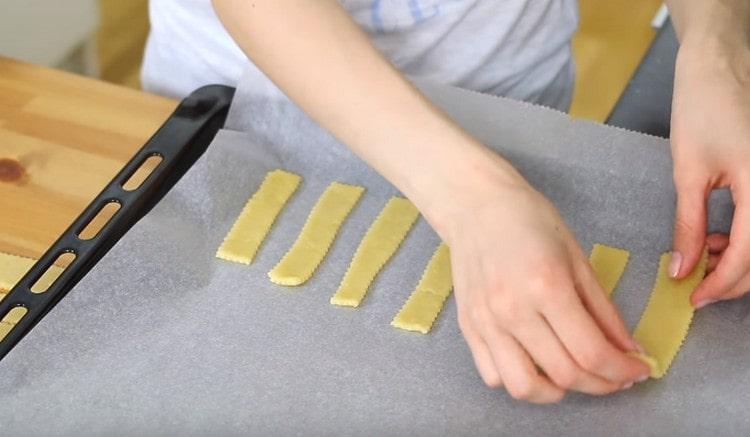 Cambiamos las galletas a una bandeja para hornear cubierta con pergamino.