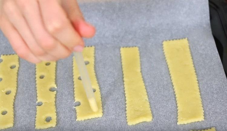 Puedes hacer agujeros en las pajitas en los espacios en blanco para que las galletas se parezcan al queso.