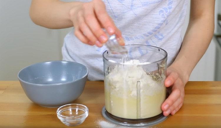 Ensuite, ajoutez le sel, la farine et la vodka dans la masse beurre-fromage.