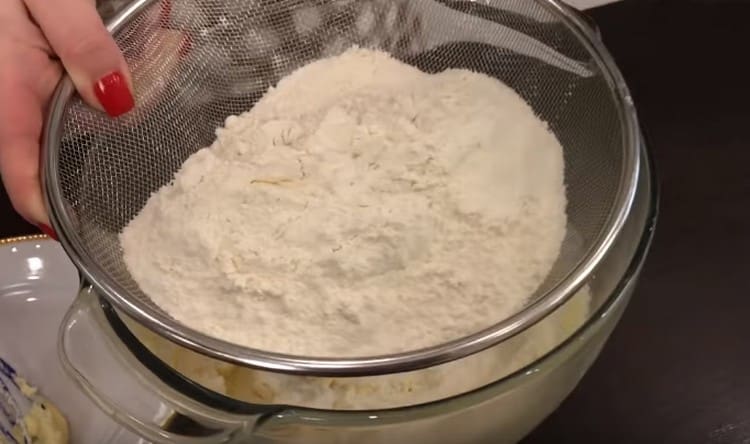 Tamiser la farine dans la pâte par parties.