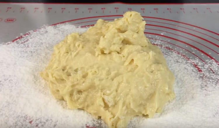 Lorsque la pâte devient plus épaisse, placez-la sur une surface saupoudrée de farine et pétrissez-la avec les mains.