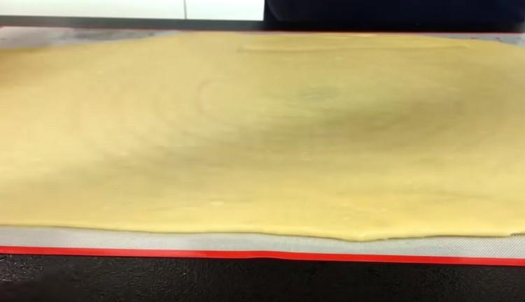 On the work surface greased with vegetable oil, roll out the dough as thin as possible.