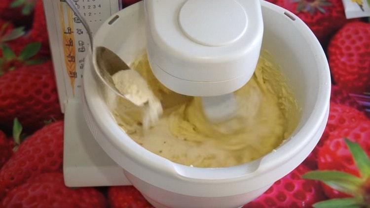 Ajouter la farine tamisée en petites portions et pétrir la pâte liquide.