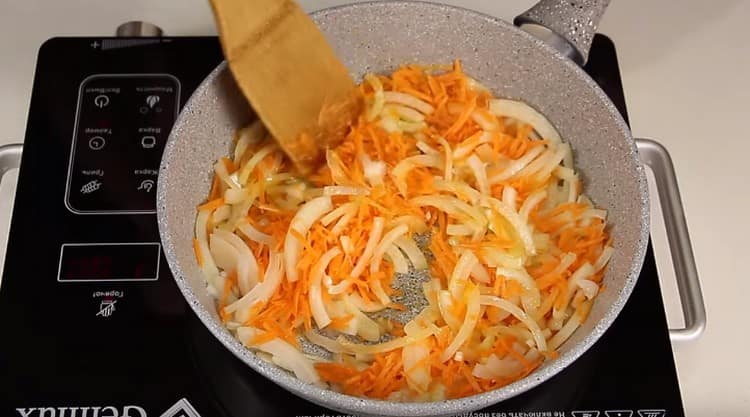 Freír las cebollas con zanahorias en una sartén.