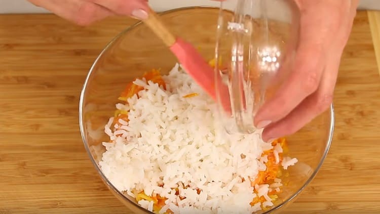 Dans un bol, nous combinons du poisson, des oignons avec des carottes et du riz.