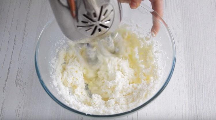 Battre le beurre avec le sucre avec un mixeur jusqu'à l'obtention d'une masse grasse.