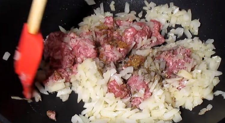 Add minced meat to the onion, as well as spices.