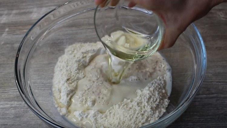 Dodajte biljno ulje i smjesu kvasca u brašno.