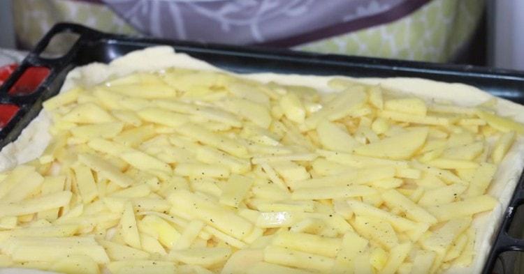 Mettez les pommes de terre avec la première couche de la tarte.