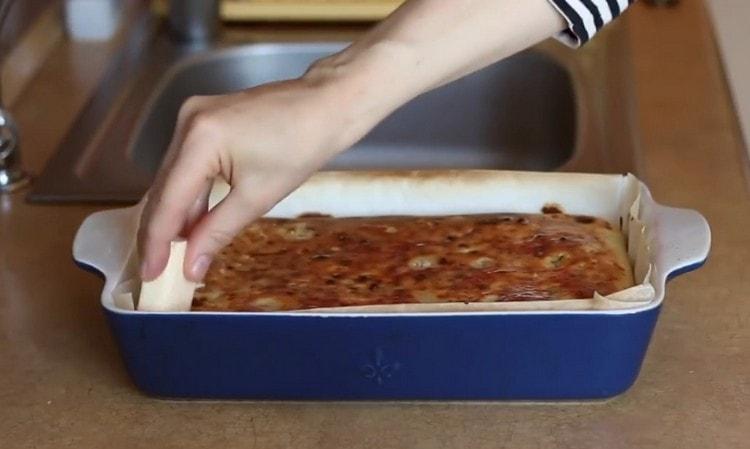 Sacamos el pastel del horno y engrasamos con un trozo de mantequilla.