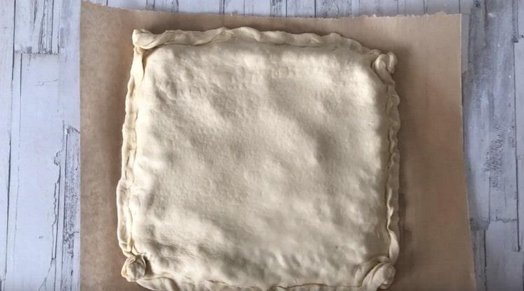 cover the filling with a second sheet of dough, carefully pinch the edges.