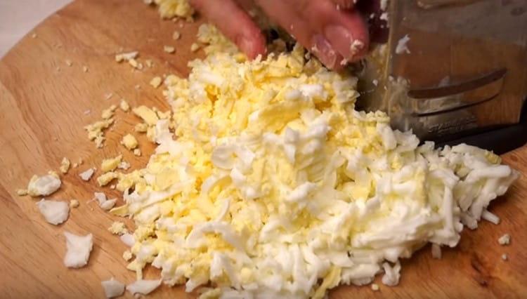 On a coarse grater we rub hard cheese and eggs.