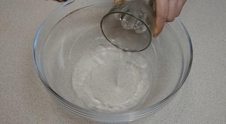 Pour warm water into a bowl to knead the dough.