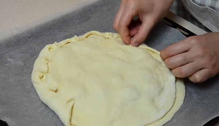 Cover the filling with another piece of dough and carefully pinch the edges.