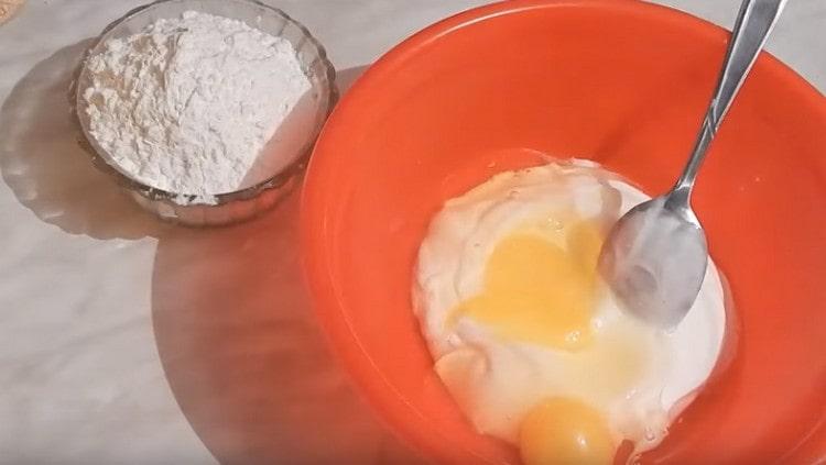 Mettez la mayonnaise et la crème sure dans un bol. battre les œufs à eux.